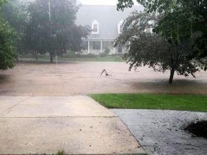 Flooded road with home in distance